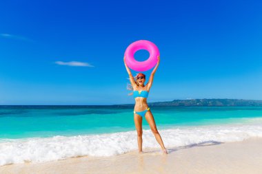 Genç güzel kız mavi bikini bir tropikal bea üzerinde eğleniyor