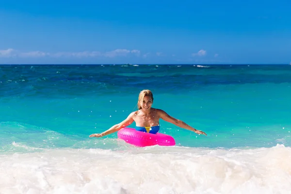 Mooie meisje in bikini zwemt in een tropische zee op een rubb — Stockfoto