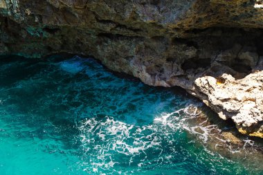 Bir kayalık uçurum bir tropikal turkuaz denize görüntülemek.