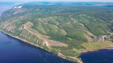 İnsansız hava aracından, Volga Nehri 'nin su alanındaki dağ ormanının üzerinden araziye doğru giden hava görüntüsü. Rusya 'nın orta bandosunda yaz tatili kavramı.
