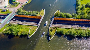 Aquaduct Veluwemeer, Nederland. İHA 'nın hava görüntüsü. Bir yelkenli, otoyolun üstündeki göldeki su kemerinden geçiyor..