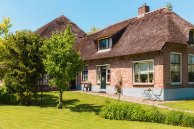 Giethoorn, Hollanda, 30 Mayıs 2021. Hollanda 'nın ünlü köyü Giethoorn geleneksel Hollanda evleri, bahçeleri, su kanalları ve ahşap köprüleri ile 