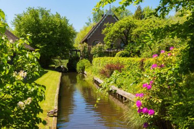 Giethoorn, Hollanda, 30 Mayıs 2021. Hollanda 'nın ünlü köyü Giethoorn geleneksel Hollanda evleri, bahçeleri, su kanalları ve ahşap köprüleri ile 