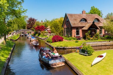Giethoorn, Hollanda, 30 Mayıs 2021. Hollanda 'nın ünlü köyü Giethoorn geleneksel Hollanda evleri, bahçeleri, su kanalları ve ahşap köprüleri ile 