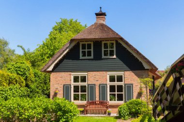 Giethoorn, Hollanda, 30 Mayıs 2021. Hollanda 'nın ünlü köyü Giethoorn geleneksel Hollanda evleri, bahçeleri, su kanalları ve ahşap köprüleri ile 