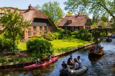 Giethoorn, Hollanda, 30 Mayıs 2021. Hollanda 'nın ünlü köyü Giethoorn geleneksel Hollanda evleri, bahçeleri, su kanalları ve ahşap köprüleri ile 