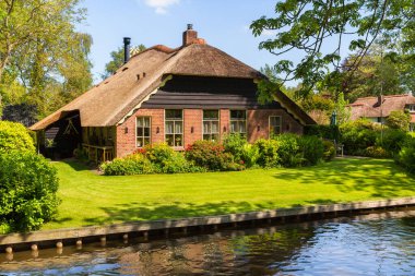 Giethoorn, Hollanda, 30 Mayıs 2021. Hollanda 'nın ünlü köyü Giethoorn geleneksel Hollanda evleri, bahçeleri, su kanalları ve ahşap köprüleri ile 