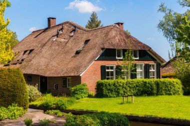 Giethoorn, Hollanda, 30 Mayıs 2021. Hollanda 'nın ünlü köyü Giethoorn geleneksel Hollanda evleri, bahçeleri, su kanalları ve ahşap köprüleri ile 