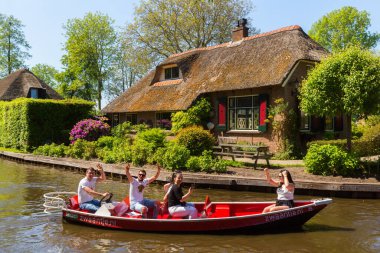 Giethoorn, Hollanda, 30 Mayıs 2021. Hollanda 'nın ünlü köyü Giethoorn geleneksel Hollanda evleri, bahçeleri, su kanalları ve ahşap köprüleri ile 