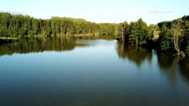 Rusya 'nın kırsal kesiminde gün batımında ormanlar arasında bir nehrin havadan görünüşü.
