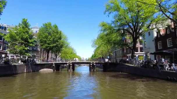 Amszterdam, Hollandia, Európa - 2021. június 10. Hagyományos régi keskeny házak és csatornák Amszterdamban, Hollandia fővárosában nyáron. — Stock videók