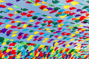 Mavi gökyüzüne karşı çok renkli kurdeleler. Bahar tatili için şehir sokaklarının şenlikli dekorasyonu..