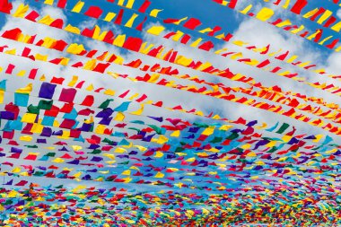 Mavi gökyüzüne karşı çok renkli kurdeleler. Bahar tatili için şehir sokaklarının şenlikli dekorasyonu..