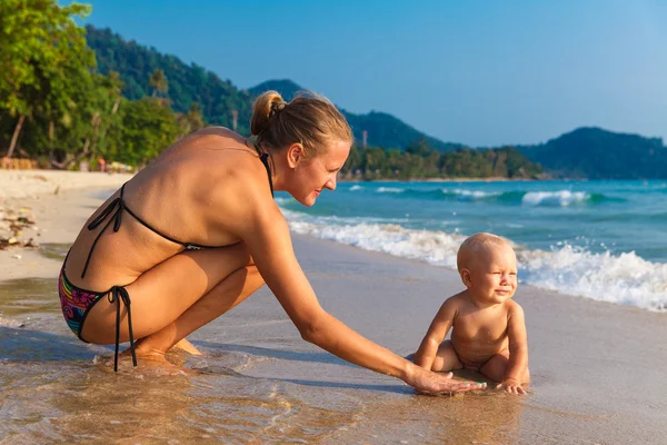 Uma jovem mãe com uma criança se divertindo em uma praia tropical.. Nat — Fotografia de Stock