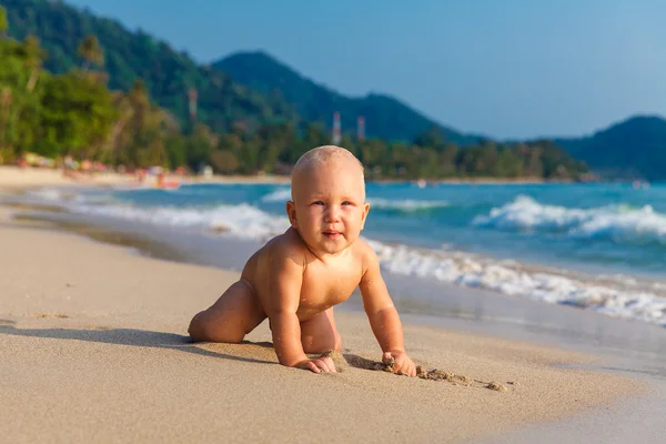 Ett litet barn ha roligt på en tropisk strand. — Stockfoto