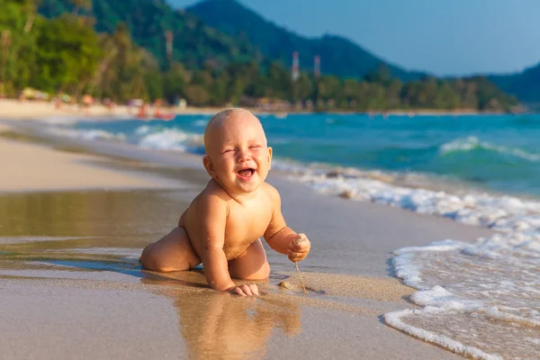 Um miúdo a divertir-se numa praia tropical . — Fotografia de Stock