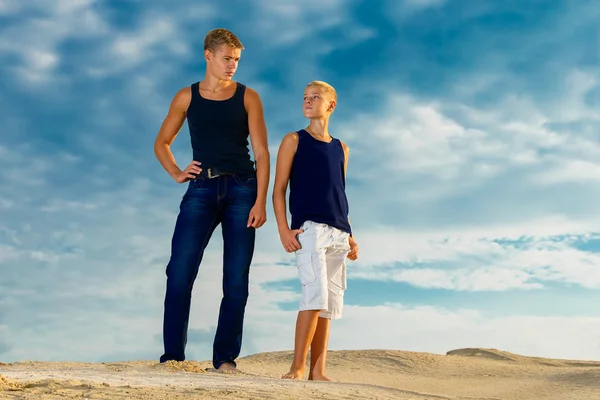 Två tonåringar att ha kul på stranden. himlen i bakgrunden — Stockfoto