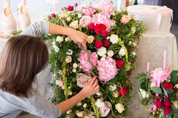 Florista en el trabajo. Mujer haciendo decoraciones florales de primavera la boda — Foto de Stock