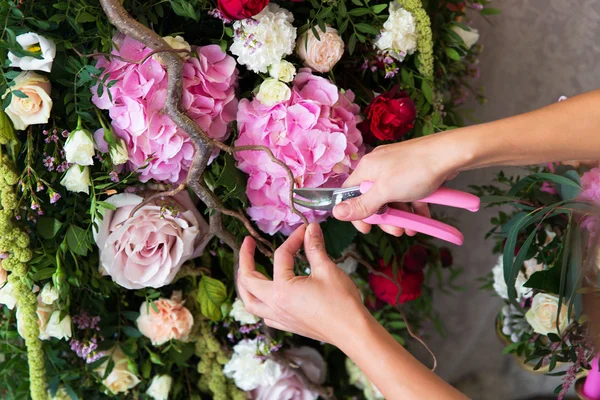 Флорист на работе. Женщина делает весенние цветочные украшения свадьба — стоковое фото