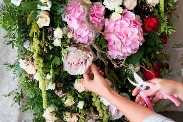 Флорист на роботі. Жінка робить весняні квіткові прикраси весілля — стокове фото