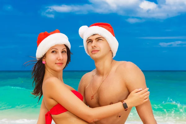 Young beautiful couple in love having fun in the waves dressed i — Stock Photo, Image