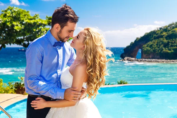 Happy bride and groom having fun on a tropical beach — Stock Photo, Image