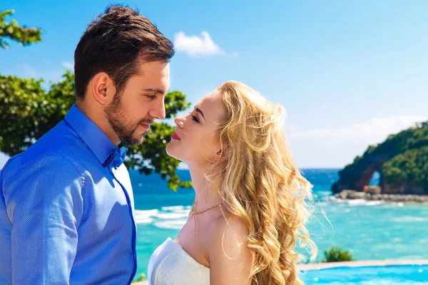 Happy bride and groom having fun on a tropical beach — Stock Photo, Image