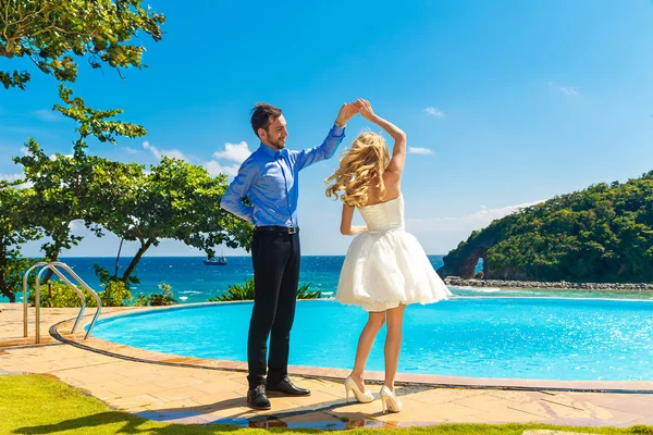 Lyckliga bruden och brudgummen att ha kul på en tropisk strand — Stockfoto