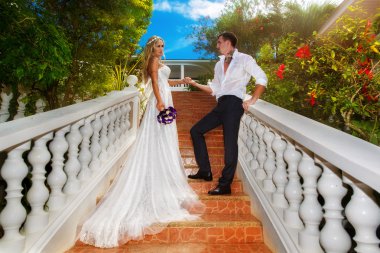 Gelin ve damat bir tropica otelde merdivenlerde ayakta