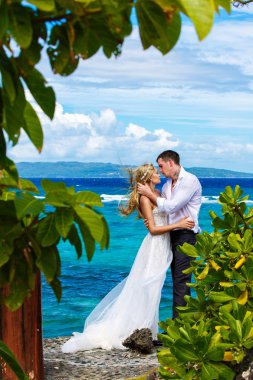 Mutlu gelin ve damat p altında tropikal bir plajda eğlenmek