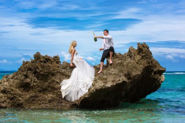 Mutlu gelin ve damat p altında tropikal bir plajda eğlenmek