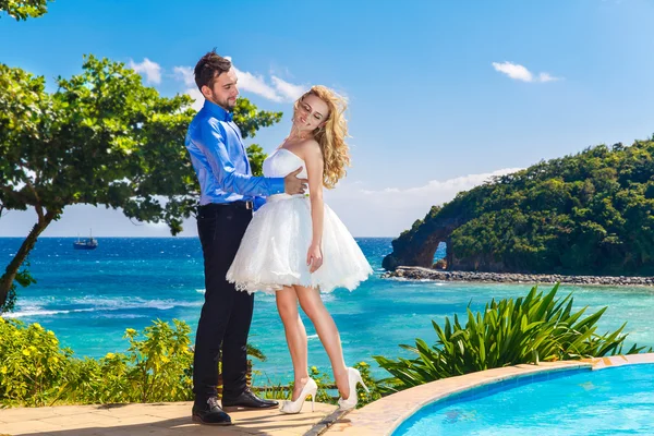 Happy bride and groom having fun on a tropical beach — Stock Photo, Image