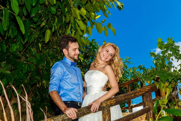 Happy bride in the wedding dress and groom smiling tropical plan — Stock Photo, Image