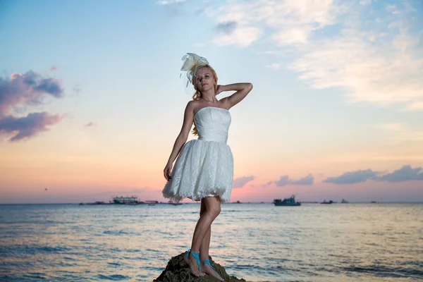 Bride on a tropical beach with the sunset in the background — Stock Photo, Image