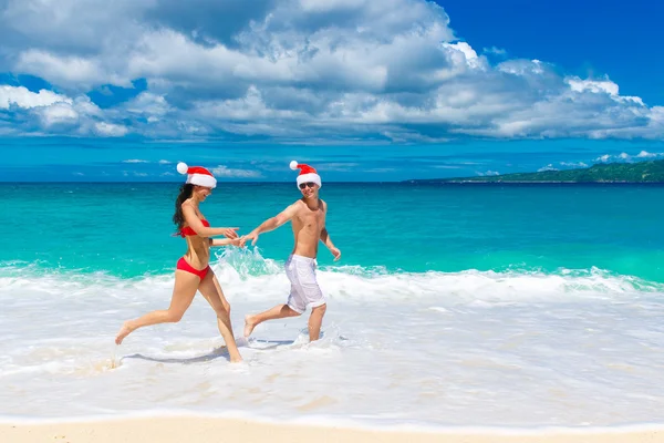 Young beautiful couple in love having fun in the waves dressed i — Stock Photo, Image