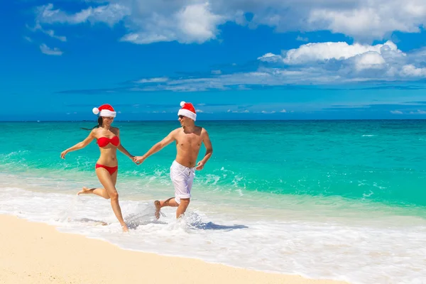 Young beautiful couple in love having fun in the waves dressed i — Stock Photo, Image