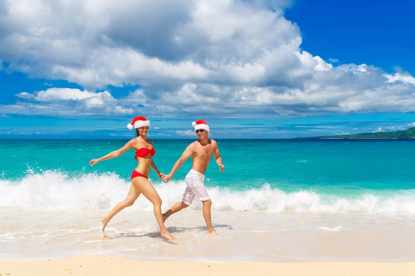 Young beautiful couple in love having fun in the waves dressed i — Stock Photo, Image