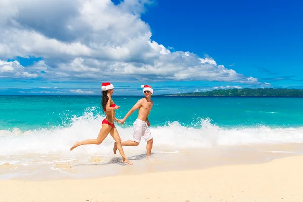 Young beautiful couple in love having fun in the waves dressed i — Stock Photo, Image