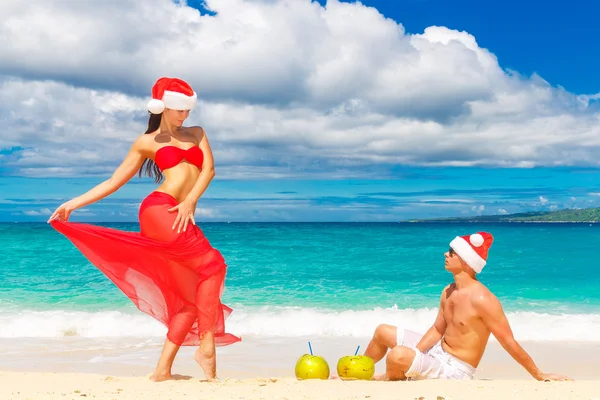 Young beautiful couple in love having fun in the waves dressed i — Stock Photo, Image