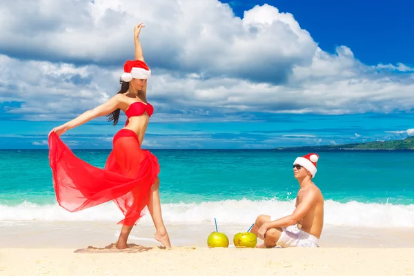 Young beautiful couple in love having fun in the waves dressed i — Stock Photo, Image