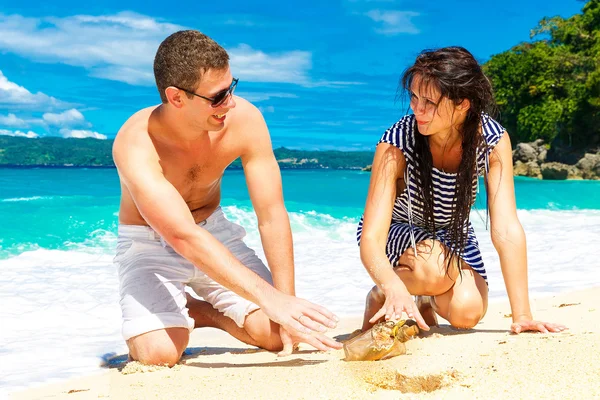 Glückliches junges Paar amüsiert sich am Ufer einer tropischen Insel. — Stockfoto