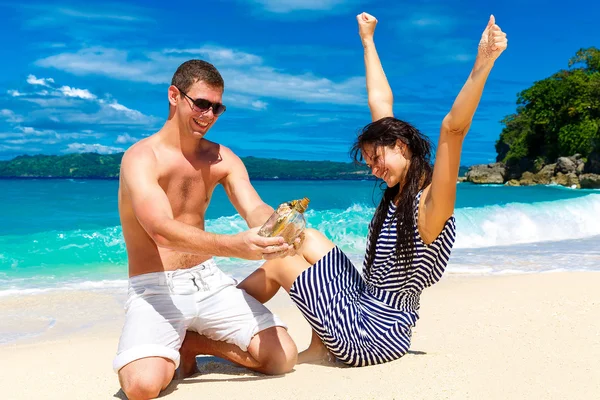 Glückliches junges Paar amüsiert sich am Ufer einer tropischen Insel. — Stockfoto