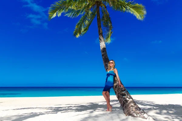 Mooie jonge vrouw met lang blond haar ontspant op de palm — Stockfoto