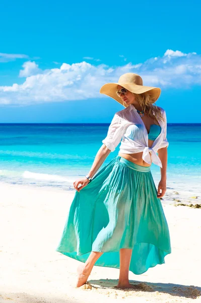 Mooi meisje in een stro hoed op een tropisch strand — Stockfoto