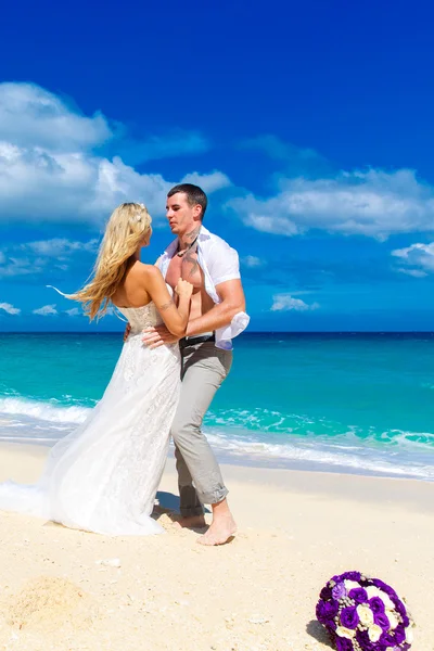 Lyckliga bruden och brudgummen att ha kul på en tropisk strand. bröllop bo — Stockfoto