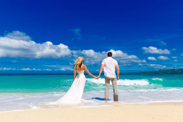 Happy bride and groom on a tropical beach — Stock Photo, Image