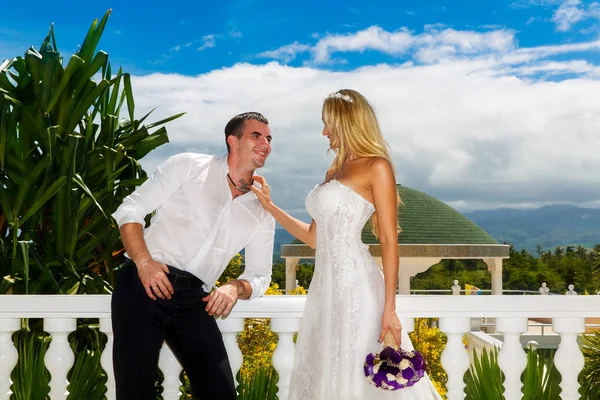 Joyeux marié et mariée debout à côté du belvédère en pierre au milieu du bea — Photo