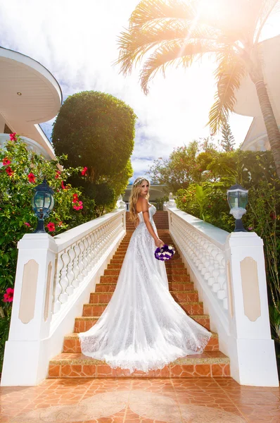 Krásná nevěsta ve svatebních šatech s dlouhou vlak, stojící na — Stock fotografie
