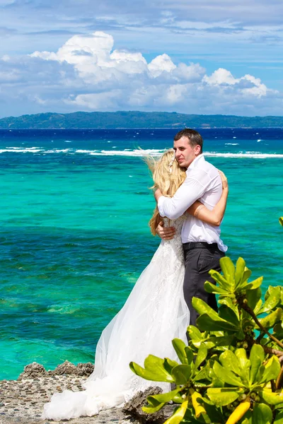 Happy bride and groom having fun on a tropical beach under the p — Stock Photo, Image