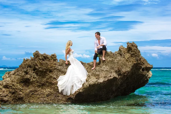 Happy bride and groom having fun on a tropical beach under the p — Stock Photo, Image